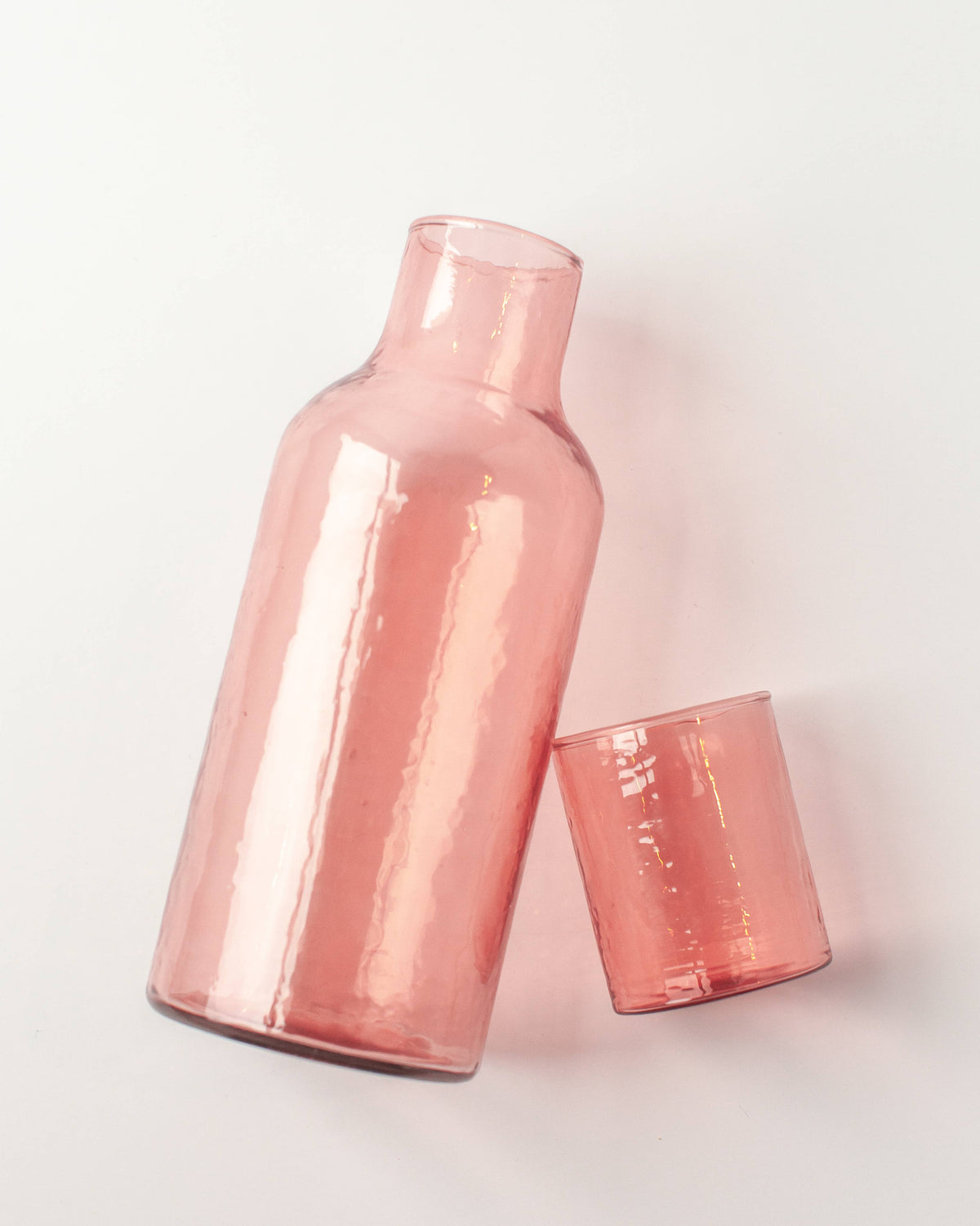 Rose gold carafe and tumbler on a light gray background
