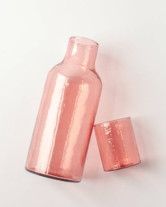 Rose gold carafe and tumbler on a light gray background