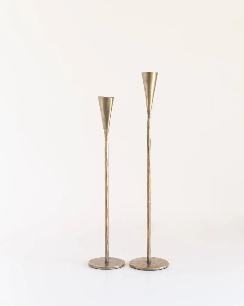 Two brass candle holders on a white background